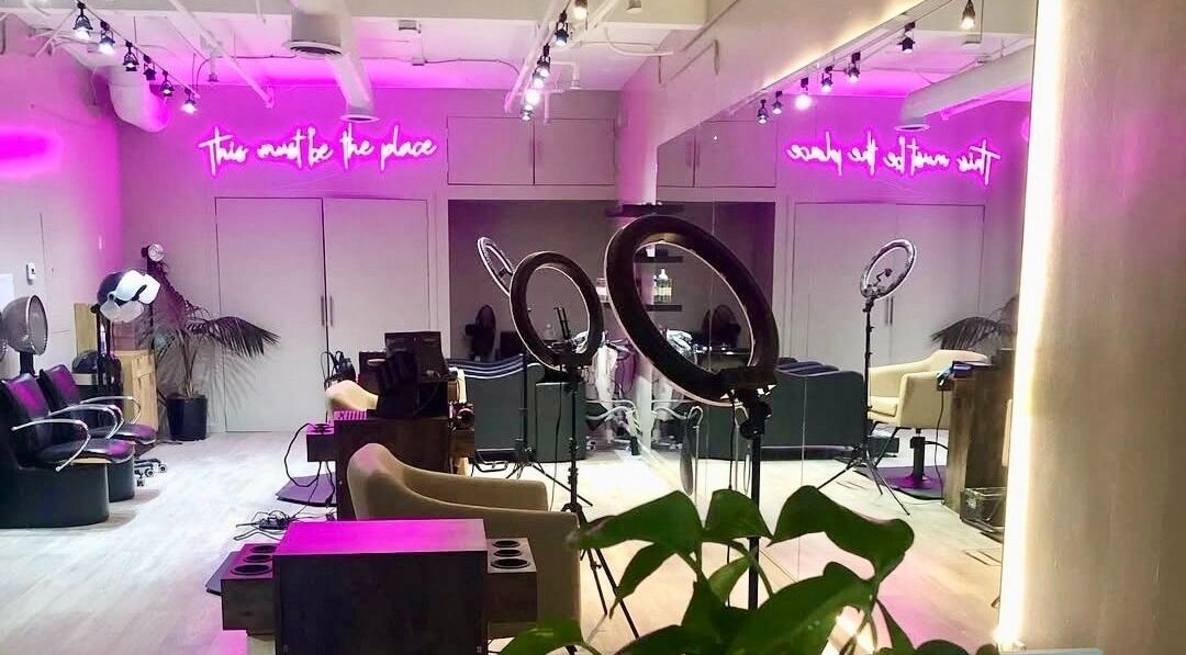 Elegant interior of Silky | The Healthy Hair Experts L.A in Los Angeles, California, US with pink neon lighting.