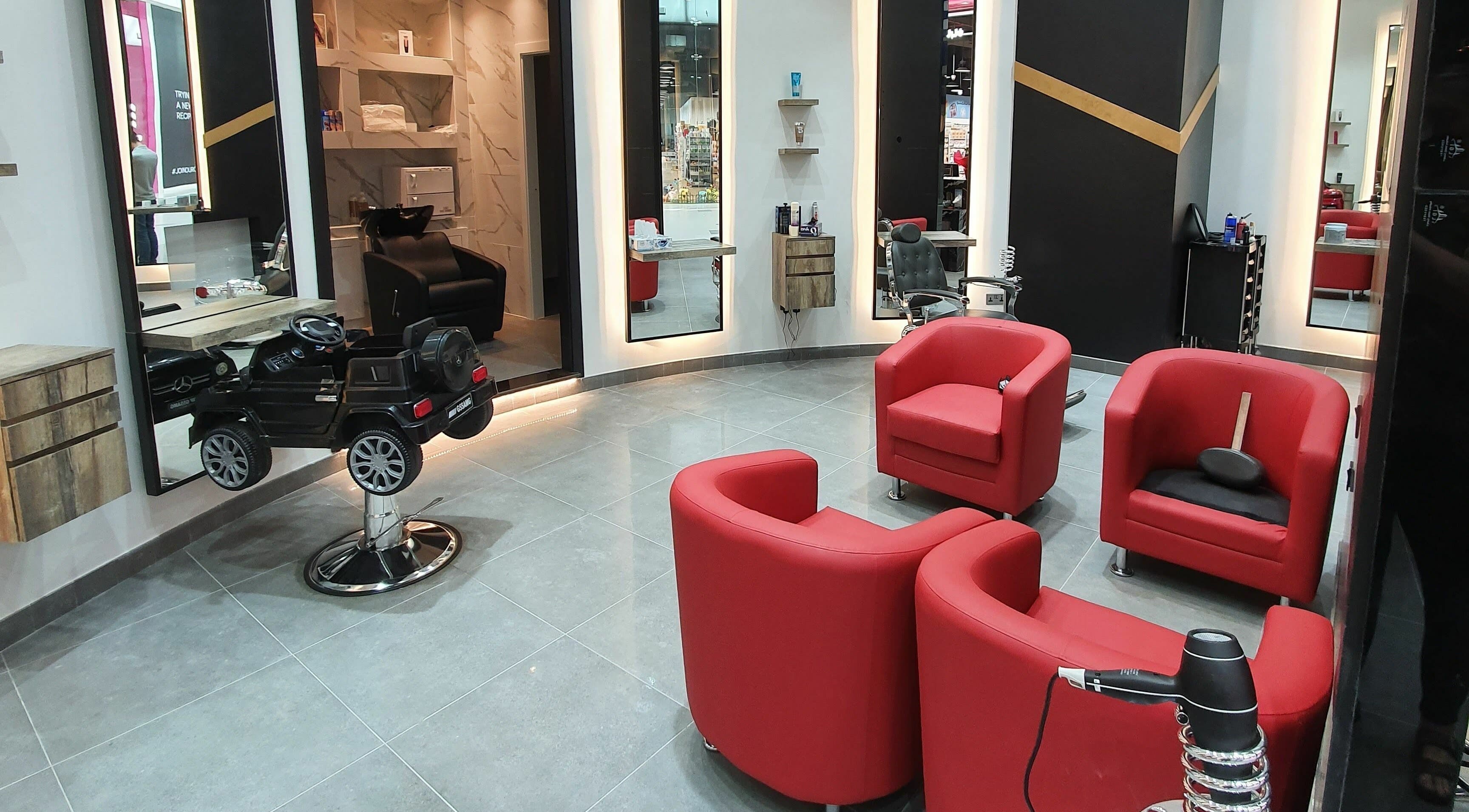 Modern salon interior with red chairs at Dear Barber Salon - Circle Mall, Dubai, AE.