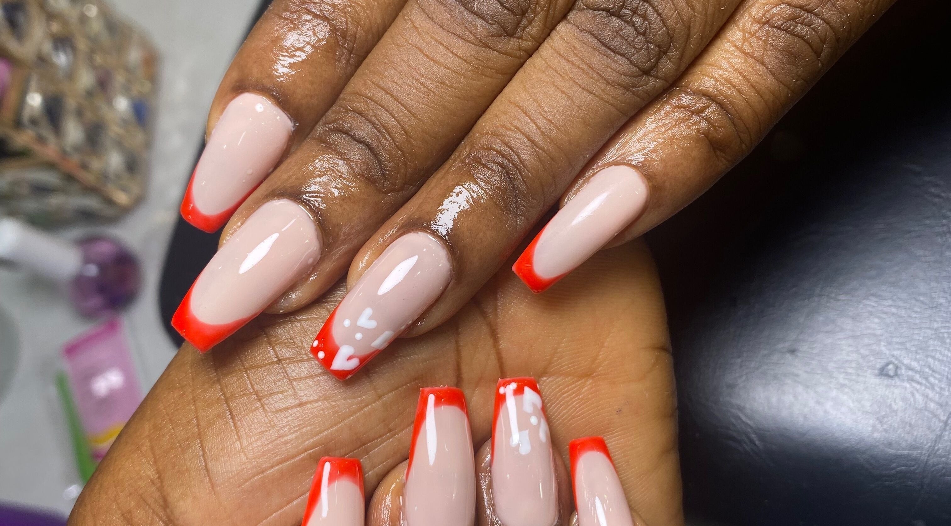 Elegant nails with bright red tips at Class Beyond Colors, Lekki, Lagos, NG showcasing expert nail artistry.