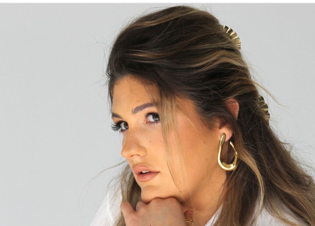 Close-up of a woman with stylish hair and gold earrings at Glow Your Way, Two Wells, South Australia, AU.