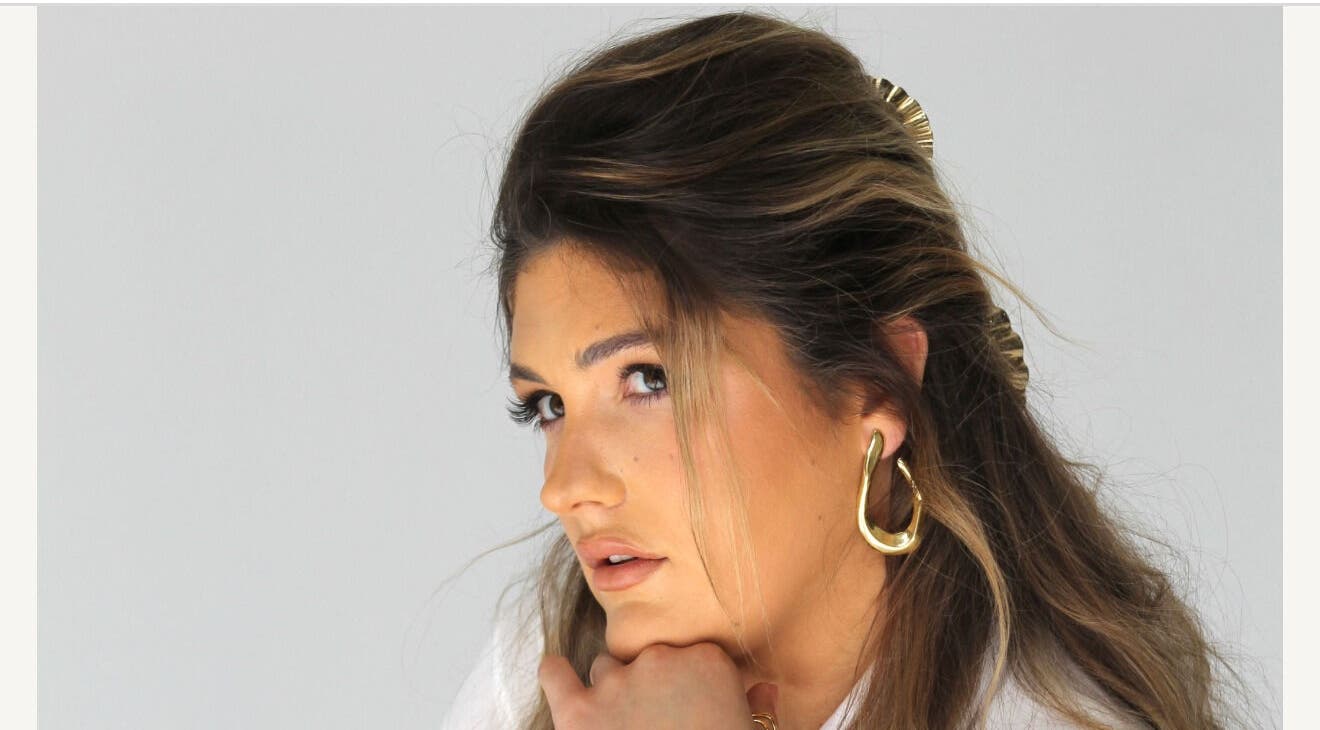 Close-up of a woman with stylish hair and gold earrings at Glow Your Way, Two Wells, South Australia, AU.