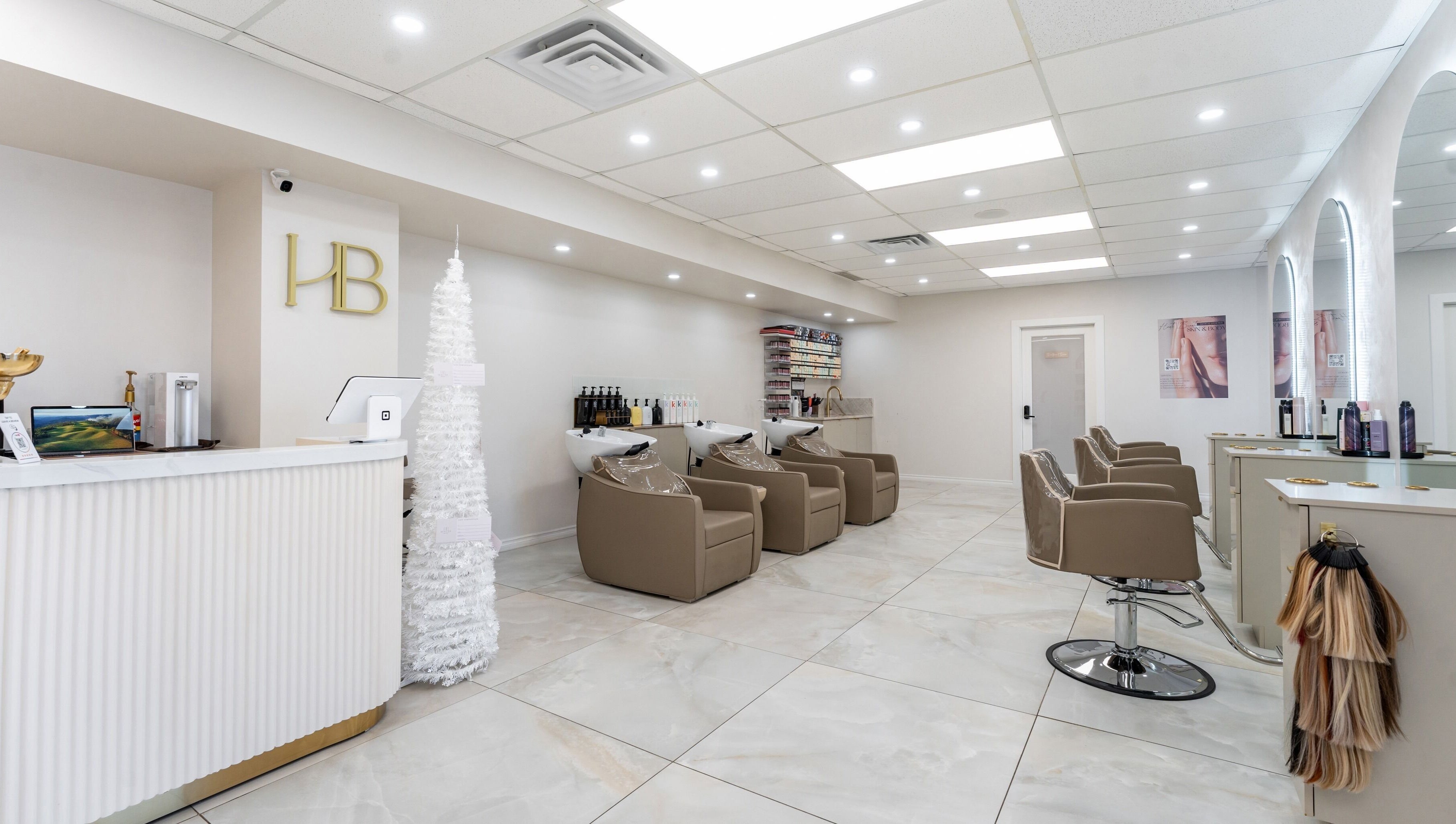 Haute Beauté salon interior with sleek design in Laval, Québec, CA. Features comfortable styling chairs and reception.