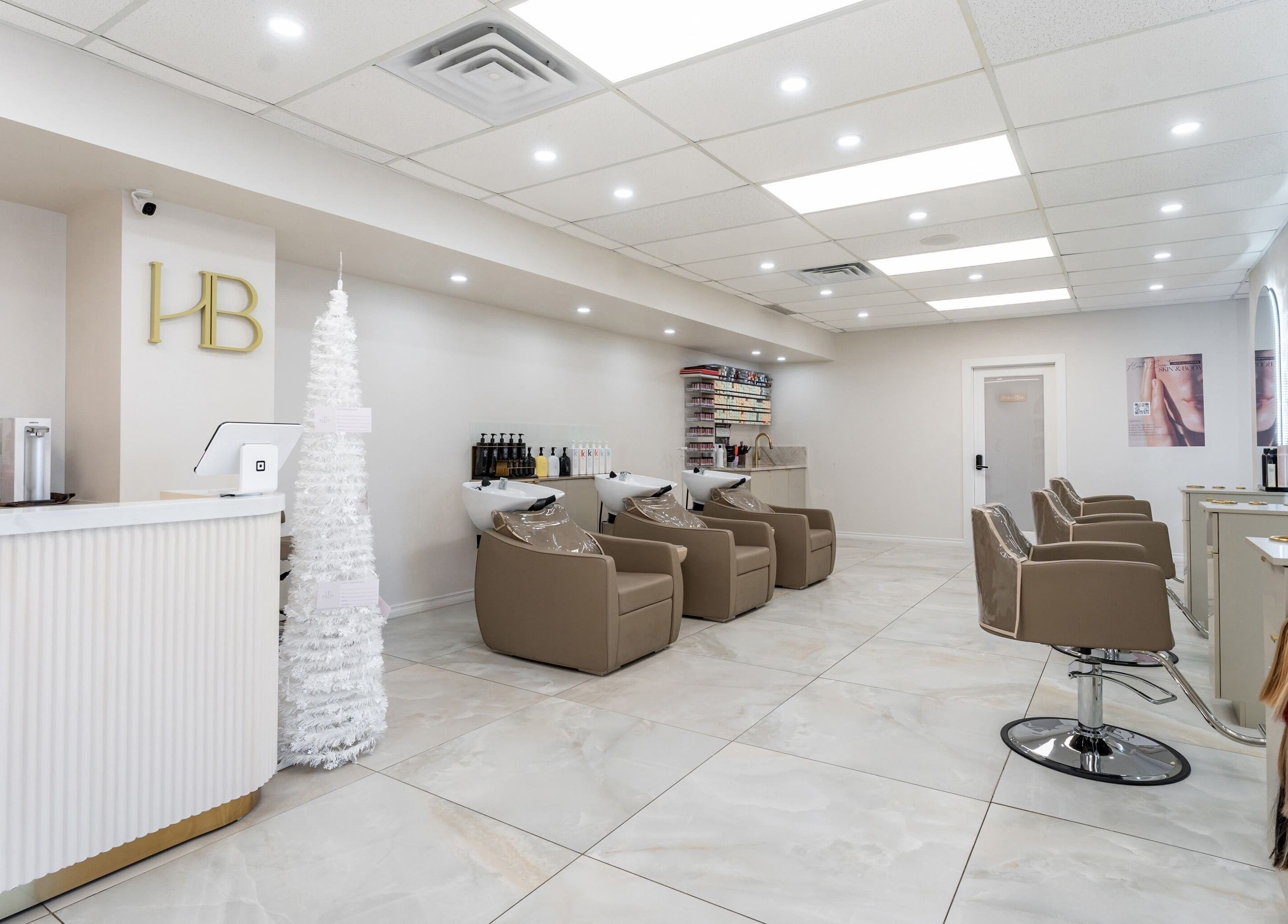 Haute Beauté salon interior with sleek design in Laval, Québec, CA. Features comfortable styling chairs and reception.