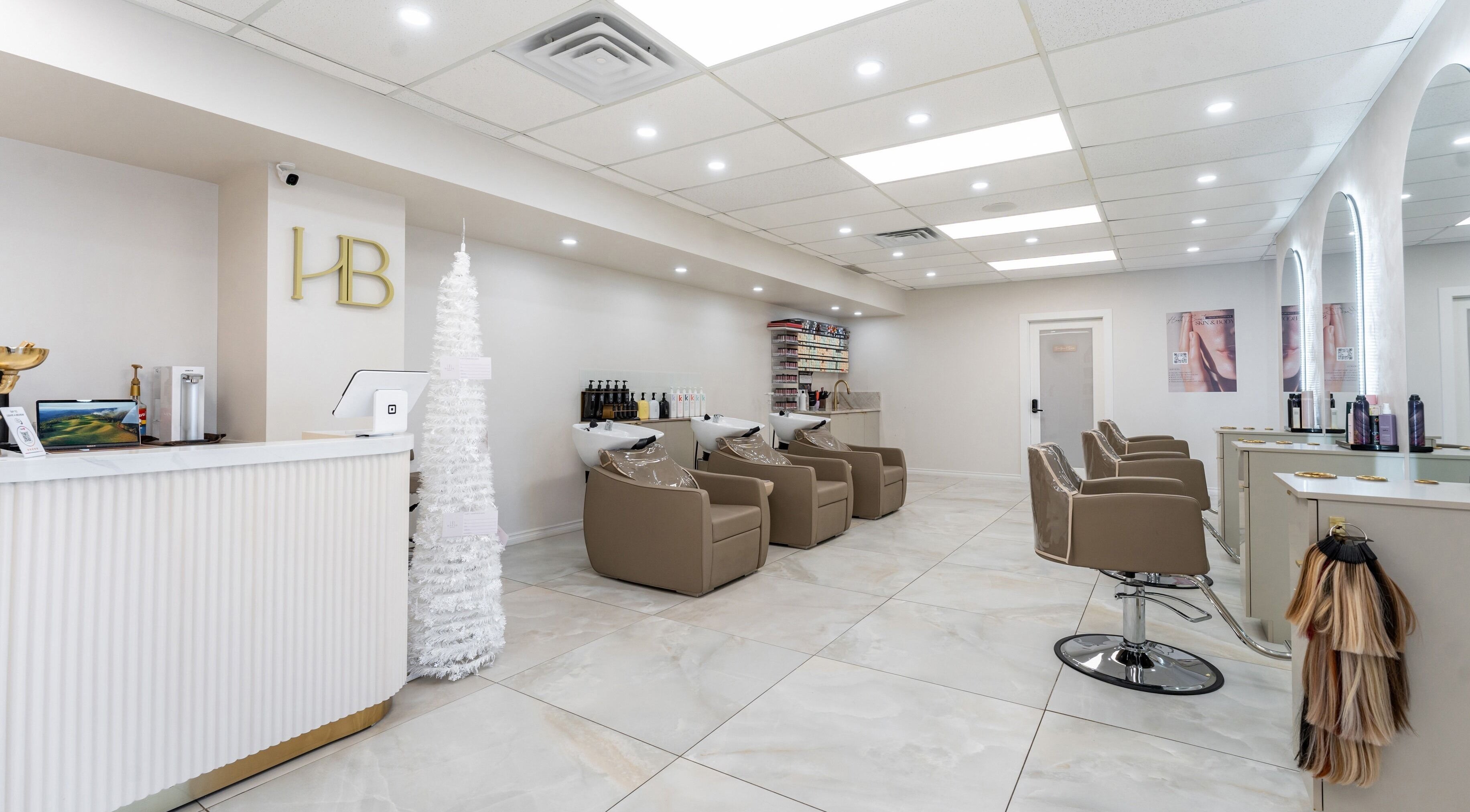 Haute Beauté salon interior with sleek design in Laval, Québec, CA. Features comfortable styling chairs and reception.