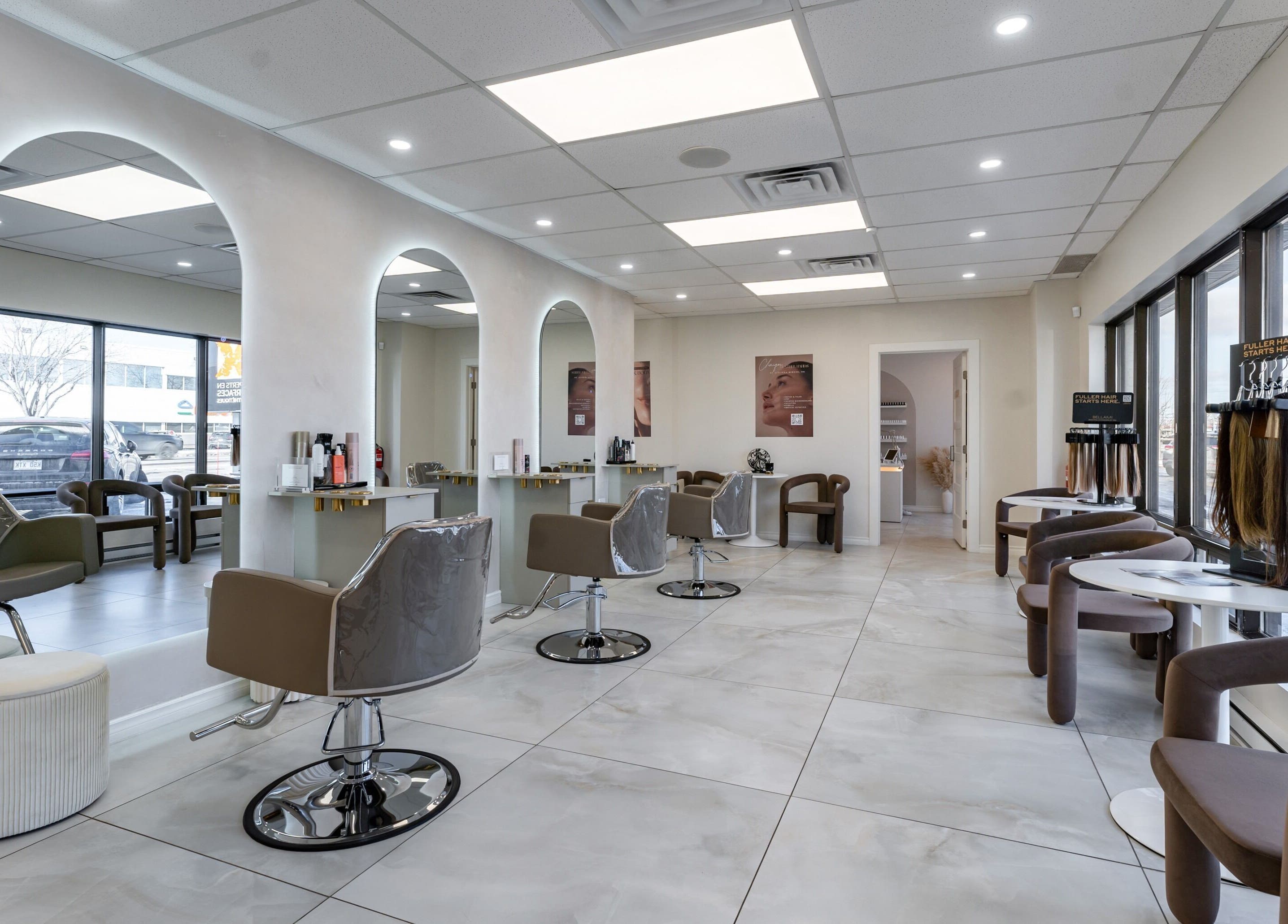 Interior of Haute Beauté salon in Laval, Québec, CA, featuring elegant chairs and mirrors under soft lighting.