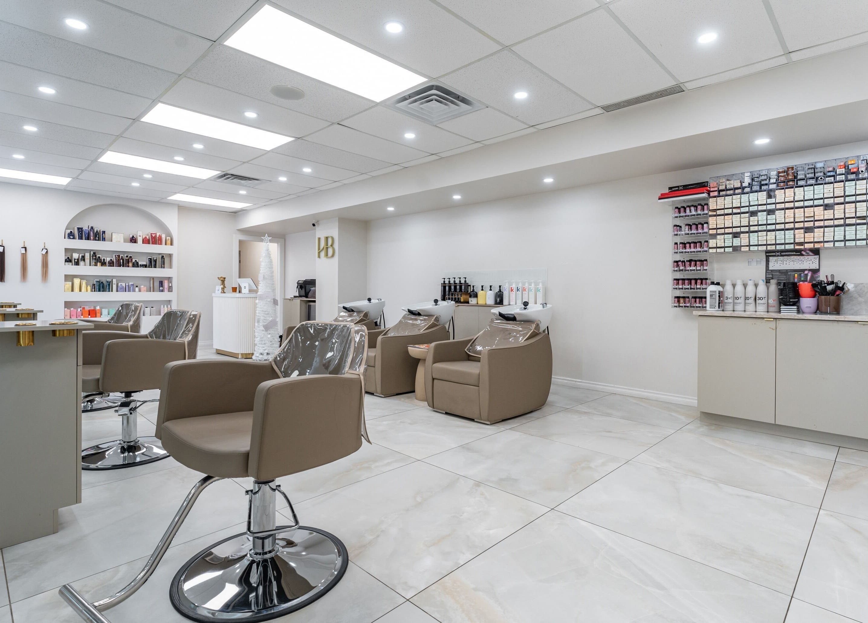 Modern salon interior at Haute Beauté in Laval, Québec, CA showcasing stylish chairs and beauty products.