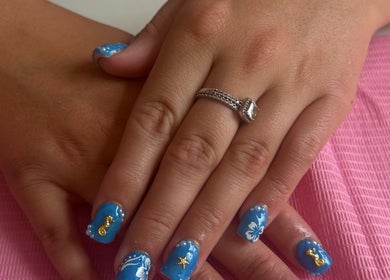 Blue nail art with sea designs at Bychloebrookesx, Edenbridge, England, GB on a pink mat.