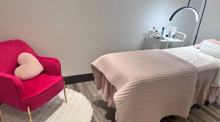 Cozy treatment room at Pure Skin Studio, Toronto, Ontario, CA with pink chair and massage table.