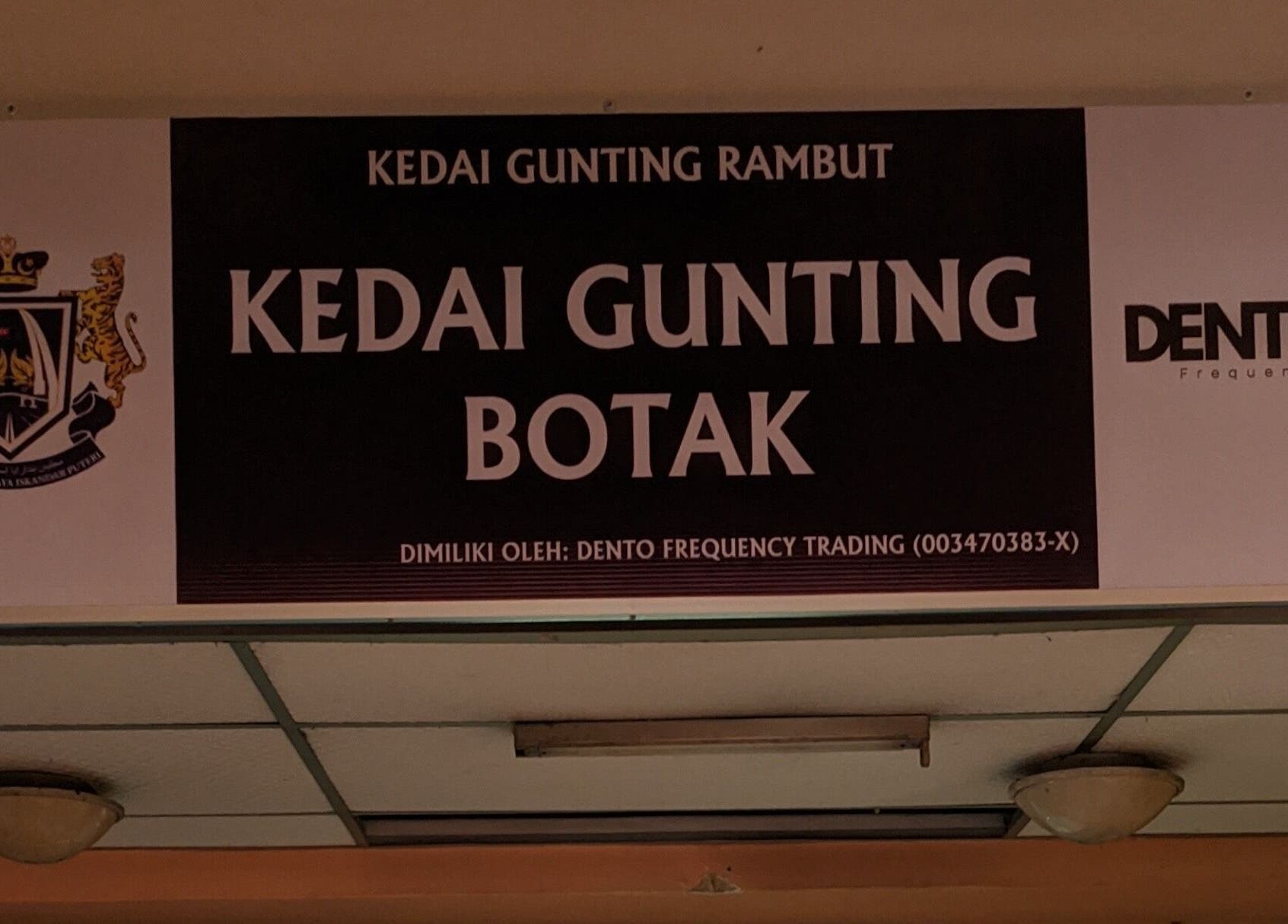 Signage of Kedai Gunting Botak in Skudai, Johor Darul Ta'zim, MY, showcasing barber's logo.