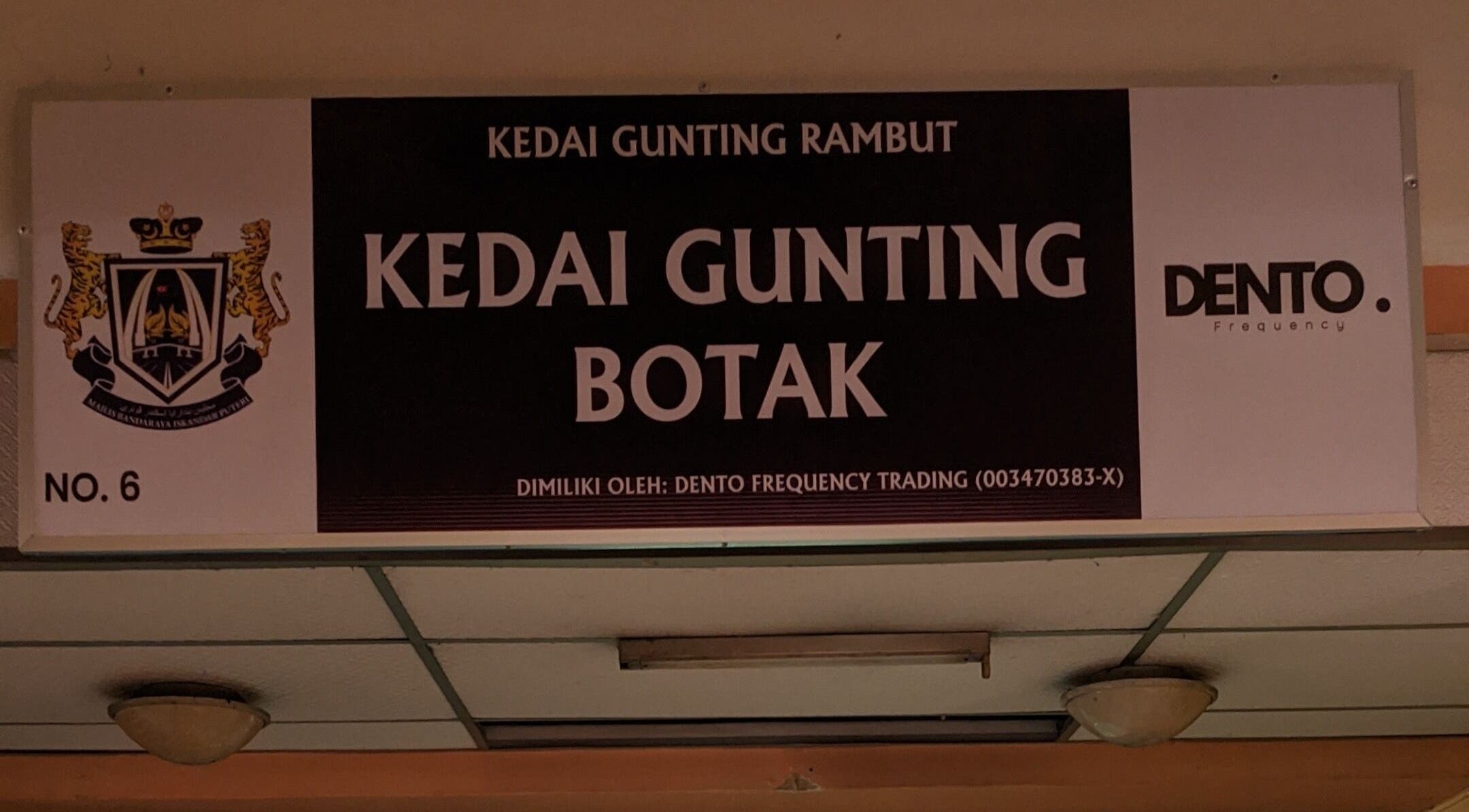 Signage of Kedai Gunting Botak in Skudai, Johor Darul Ta'zim, MY, showcasing barber's logo.