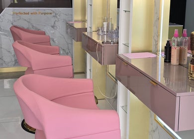 Stylish pink chairs at Beautique Umhlanga salon in Durban, ZA with sleek decor and beauty tools.