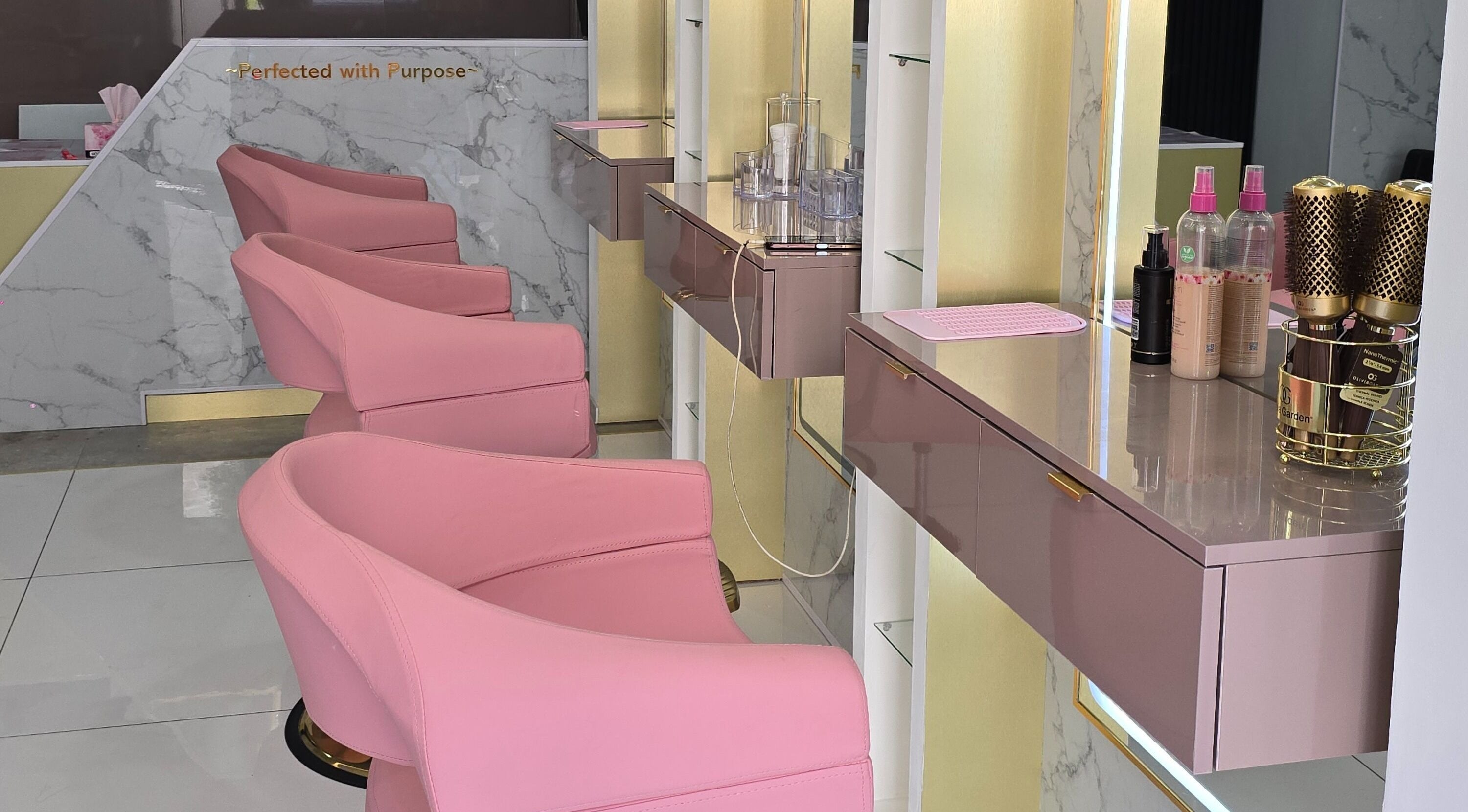 Stylish pink chairs at Beautique Umhlanga salon in Durban, ZA with sleek decor and beauty tools.