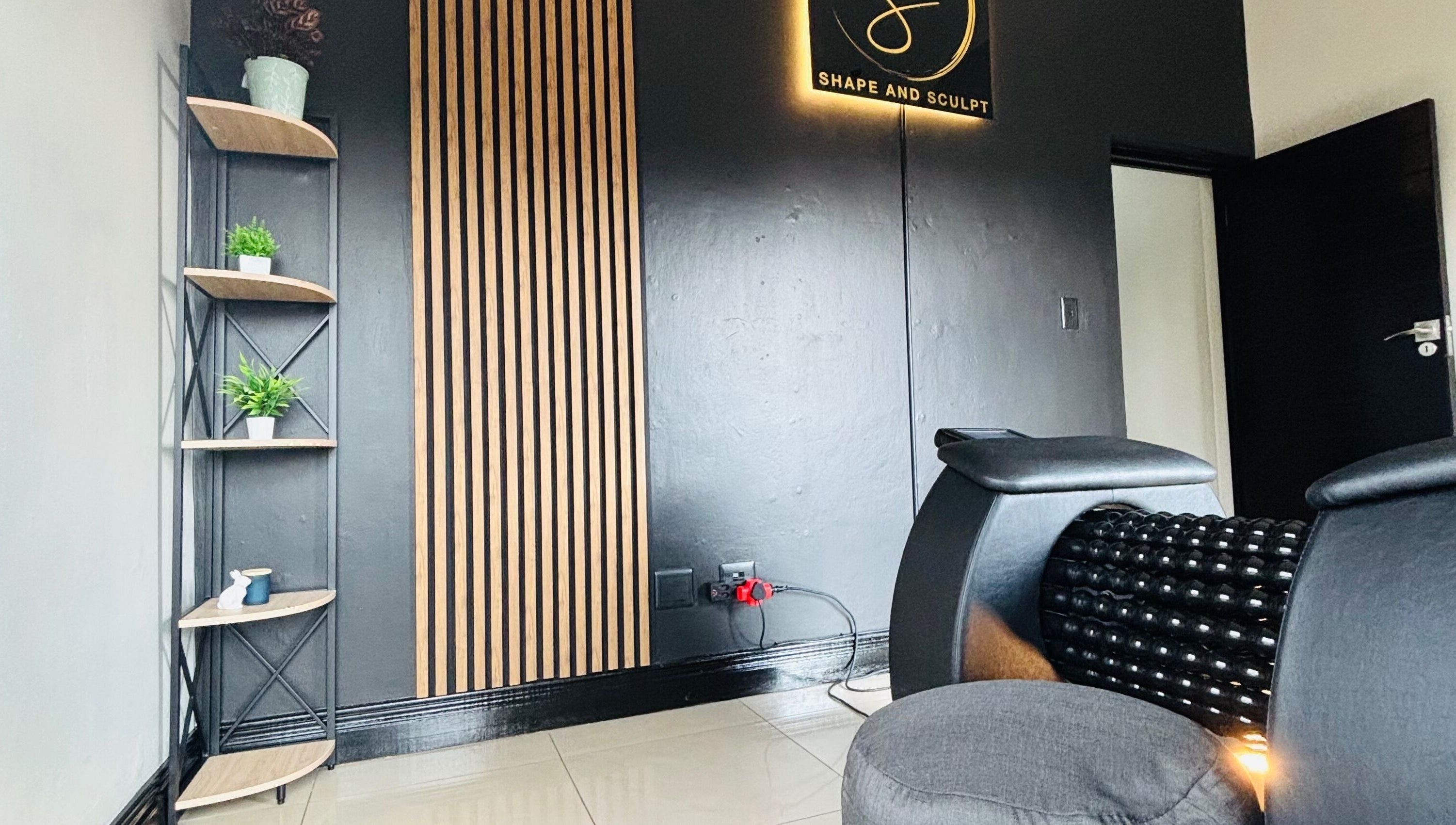 Stylish corner at Shape And Sculpt in Pretoria, Gauteng, ZA with black decor and green plants.