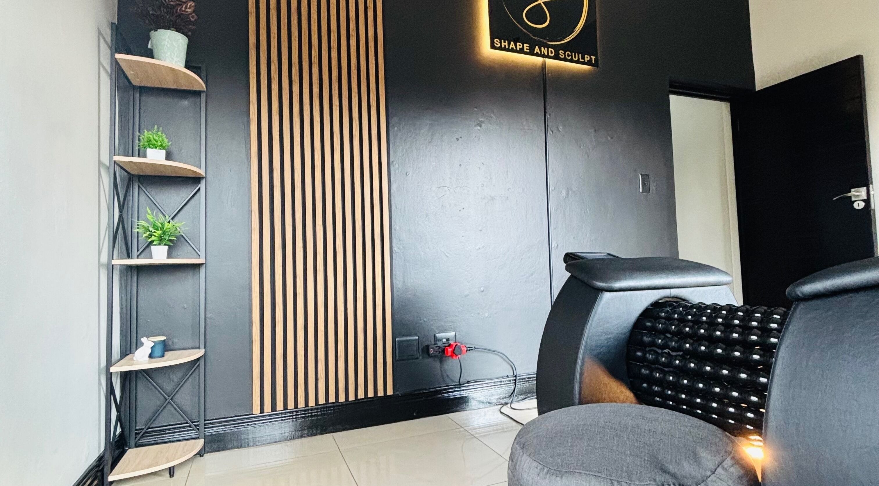 Stylish corner at Shape And Sculpt in Pretoria, Gauteng, ZA with black decor and green plants.