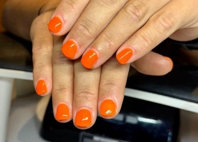 Bright orange nails by Nails by Delle in Dingwall, Scotland, GB, showcasing stylish manicure.
