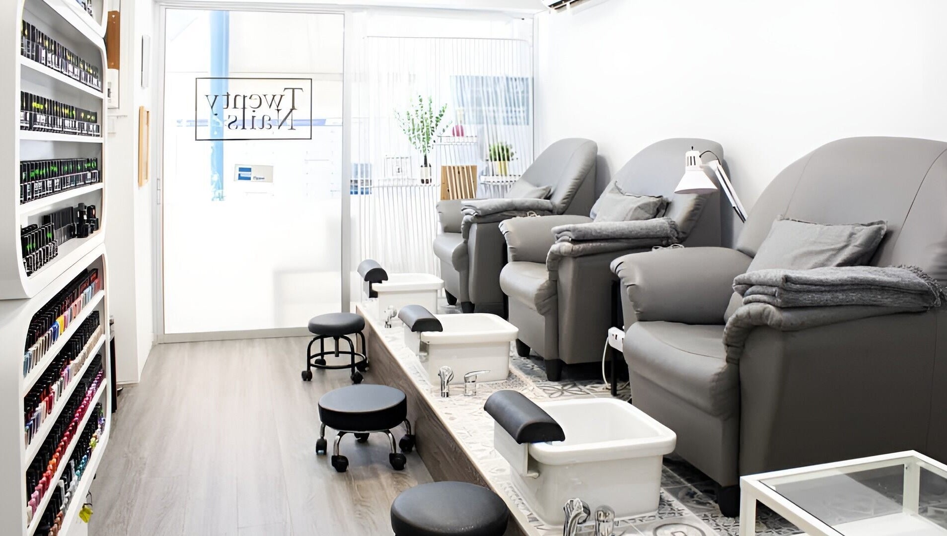 Cozy pedicure setup at Twenty Nails, Singapore, SG, featuring plush chairs and sleek foot baths.