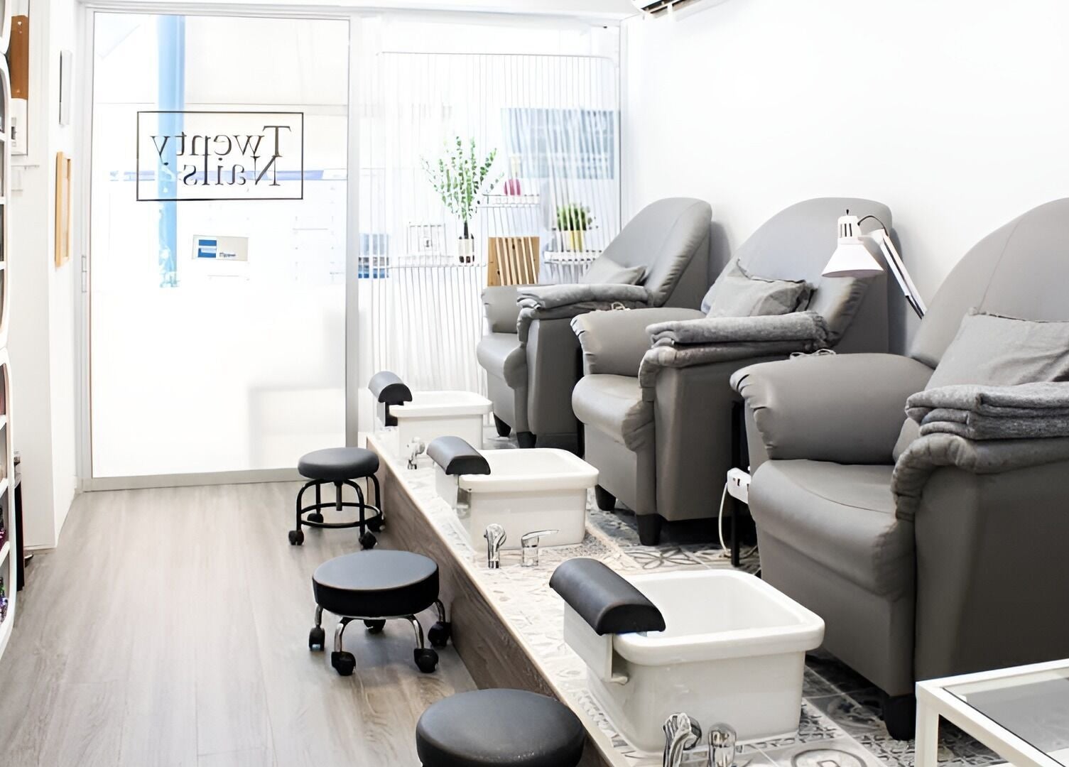 Cozy pedicure setup at Twenty Nails, Singapore, SG, featuring plush chairs and sleek foot baths.