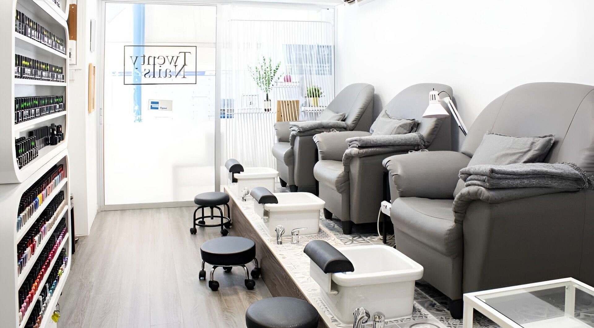 Cozy pedicure setup at Twenty Nails, Singapore, SG, featuring plush chairs and sleek foot baths.
