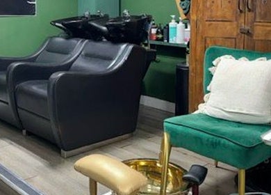 Stylish seating area at A&S Hair and Beauty Salon, London, England, GB showcasing elegant black chairs.