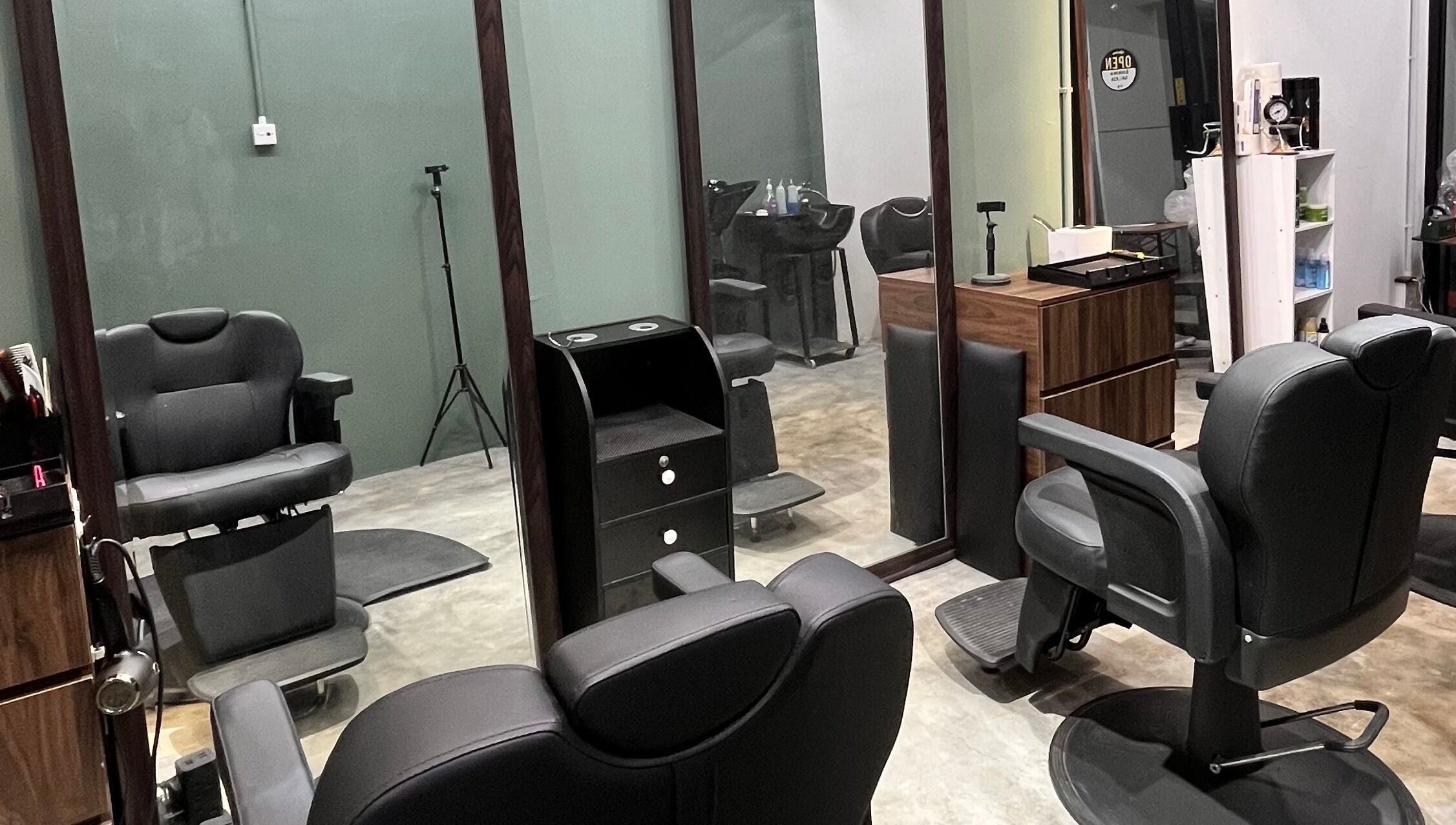 Modern barber chairs at Ayos Barbershop, Batu Caves, Selangor, MY, featuring sleek design and mirror setup.