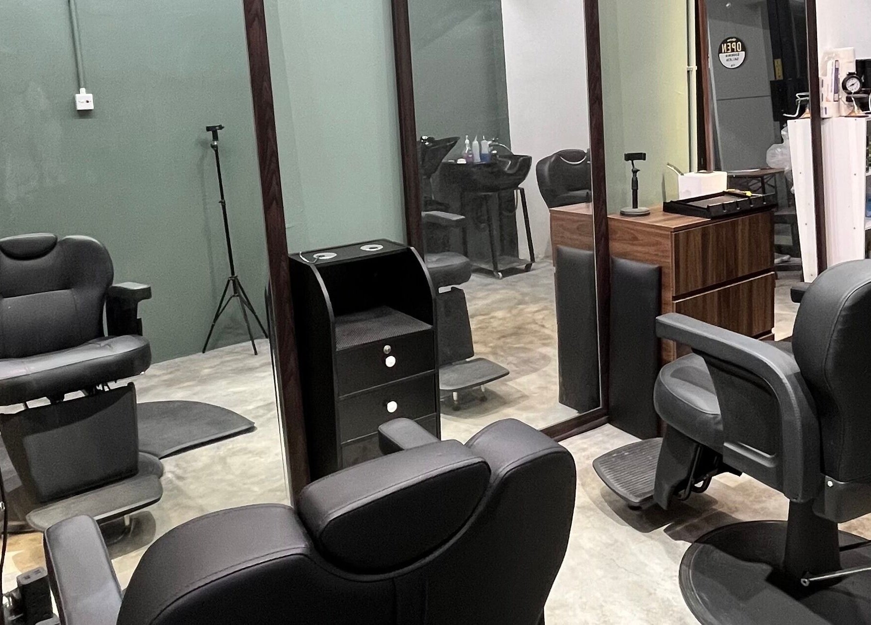 Modern barber chairs at Ayos Barbershop, Batu Caves, Selangor, MY, featuring sleek design and mirror setup.