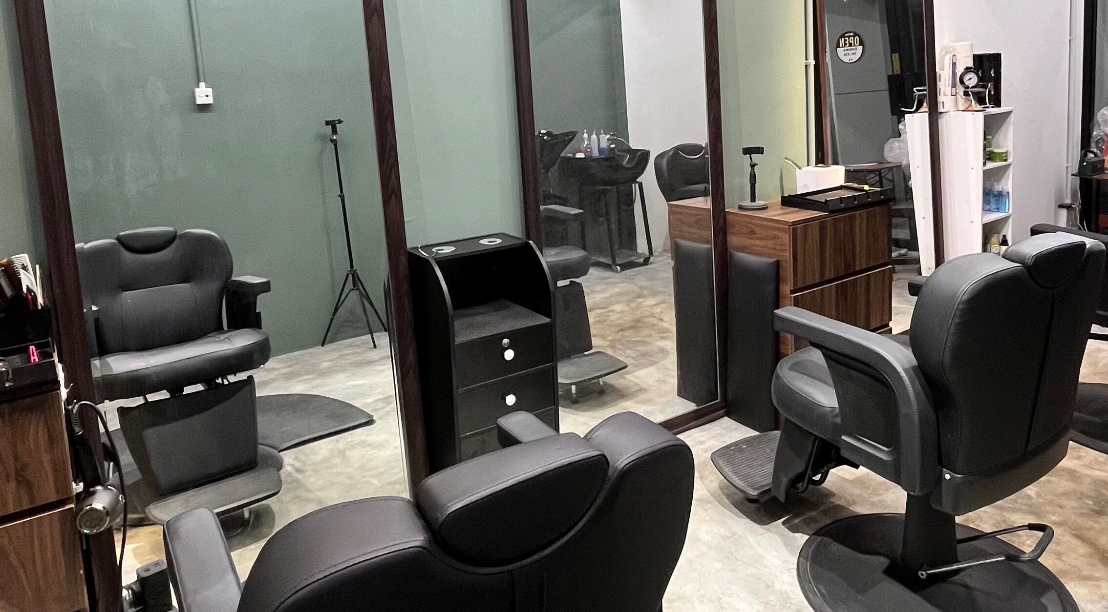 Modern barber chairs at Ayos Barbershop, Batu Caves, Selangor, MY, featuring sleek design and mirror setup.