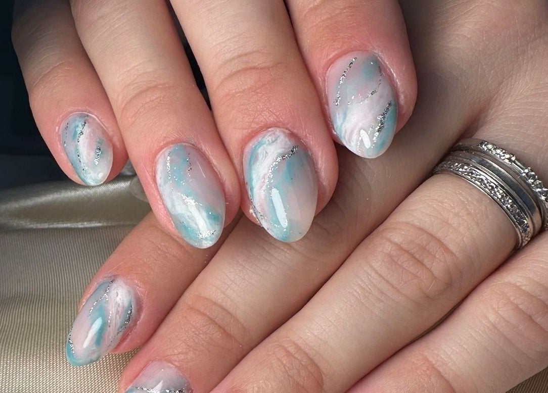 Manucure élégante de Crea'Tiff Nail à HAUT-CLOCHER, Grand Est, FR, avec des motifs bleu et argent.