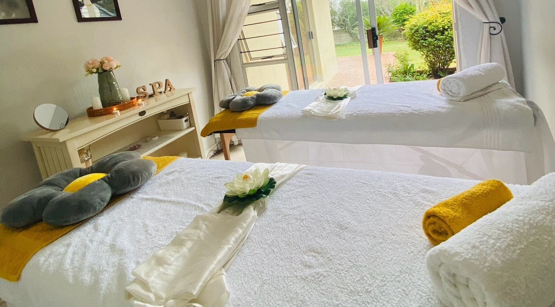 Tranquil massage room at NKANDZO Wellness Spa, Sandton, Gauteng, ZA, with plush beds and soothing decor.