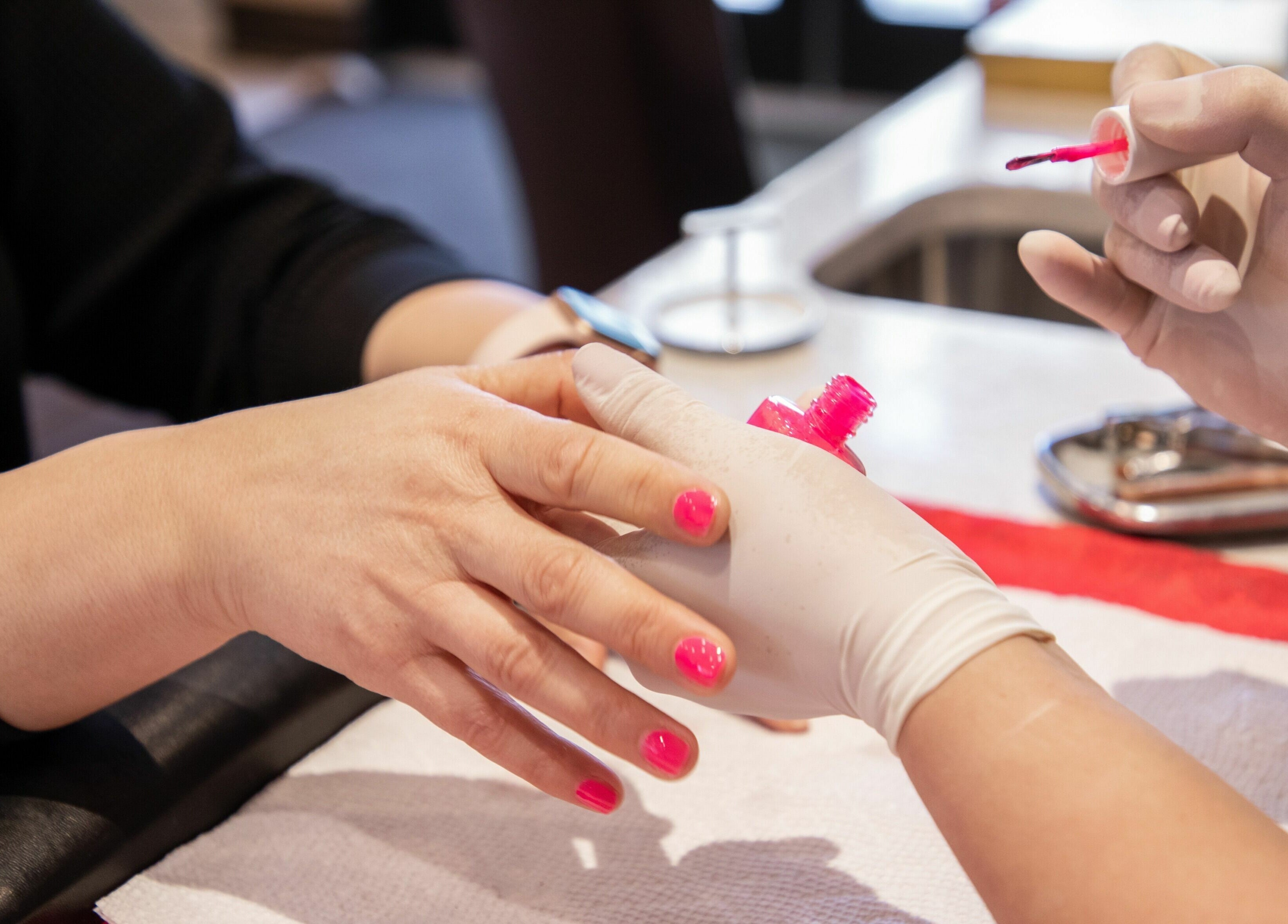 Professional manicure at Ruby Nails in Chicago, Illinois, US. Bright pink nails in elegant salon setting.