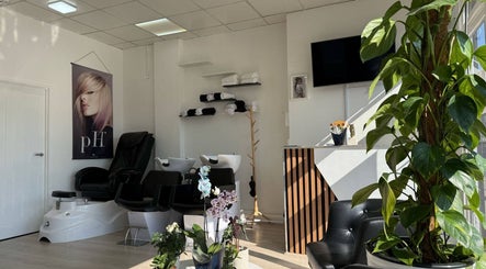 Tranquil interior of ZS Hair & Beauty in Welling, England, GB with chairs, plants, and wall art.