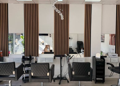 Modern salon interior at ZS Hair & Beauty in Welling, England, GB with stylish black chairs and mirrors.