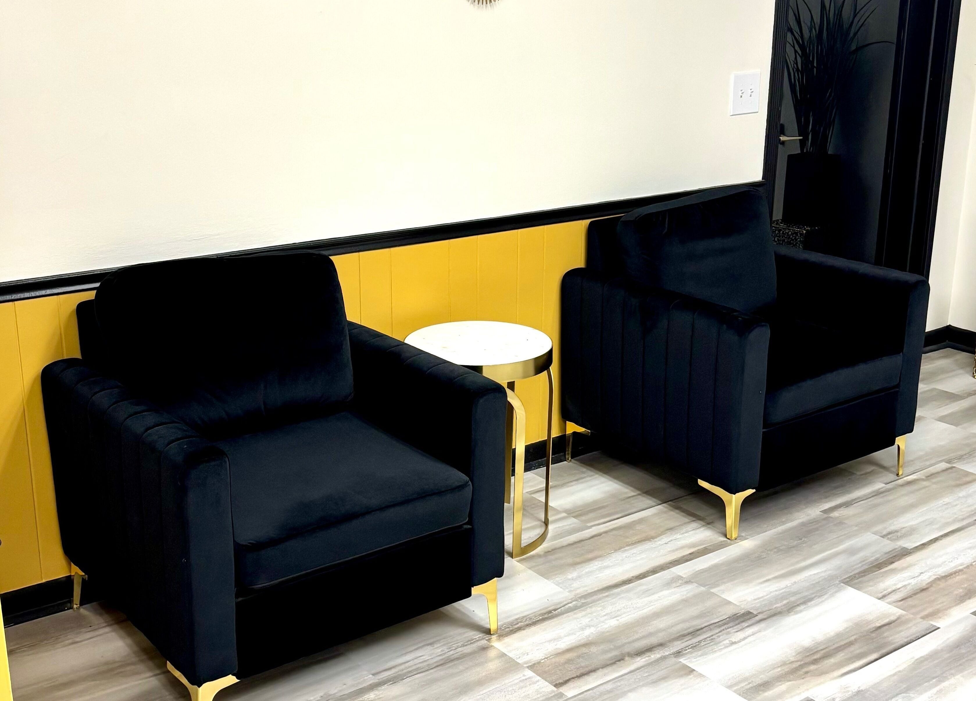 Elegant seating area at Serenity’s Remedies in Toledo, Ohio, US featuring black chairs and a sleek table.