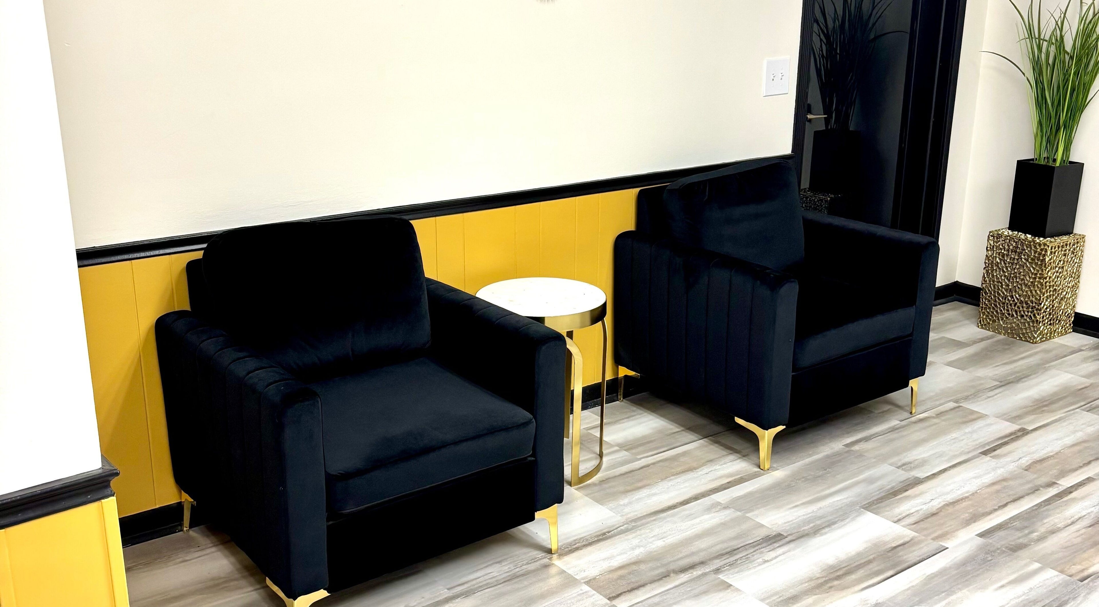 Elegant seating area at Serenity’s Remedies in Toledo, Ohio, US featuring black chairs and a sleek table.