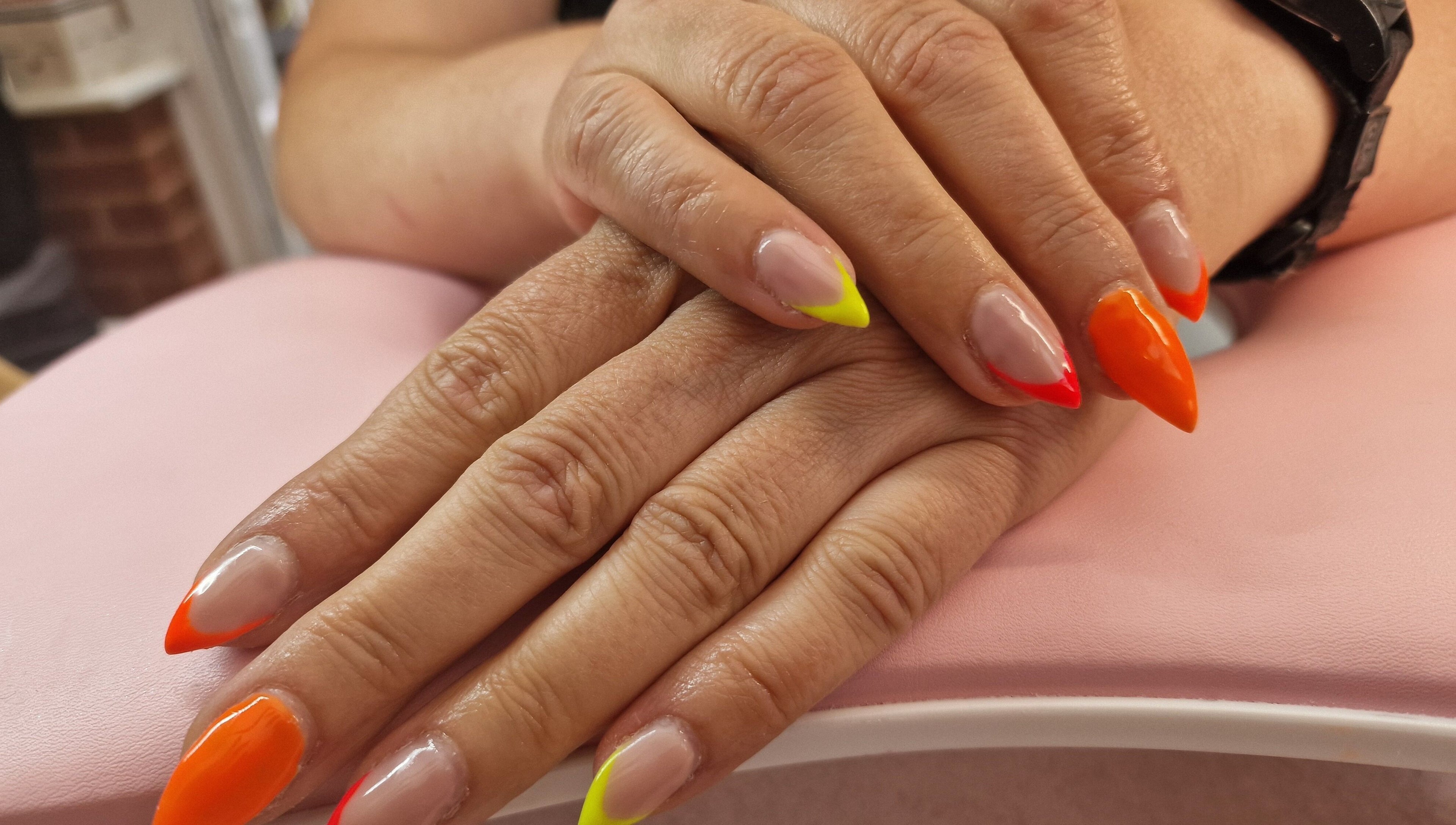 Vibrant nail art at Glamour Nails Telford, showcasing bright colors on a pink backdrop in Telford, England, GB.