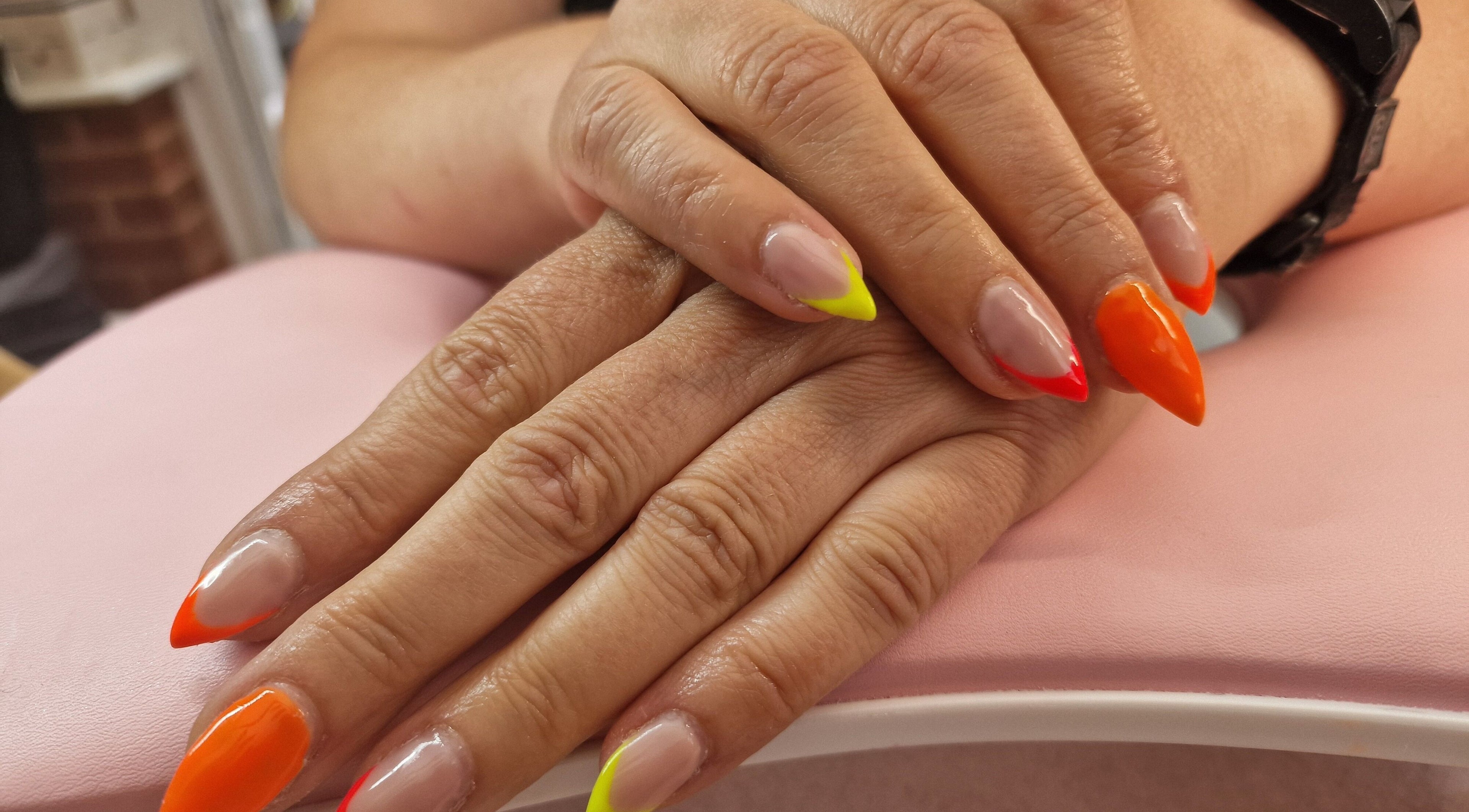 Vibrant nail art at Glamour Nails Telford, showcasing bright colors on a pink backdrop in Telford, England, GB.