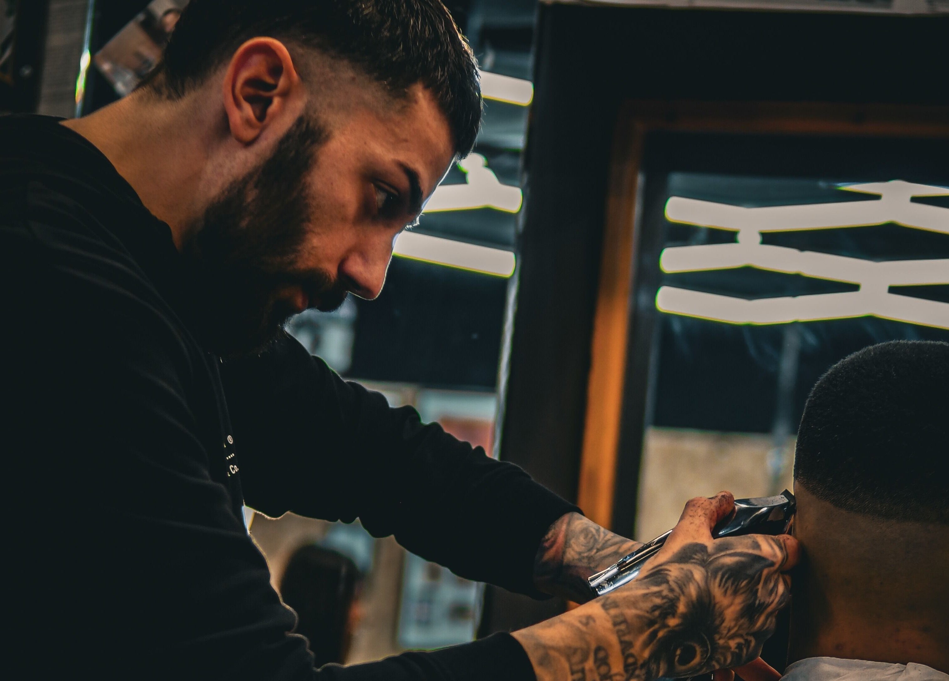 A barber styles a man's hair at Yuva by Clinton in Ħaż-Żebbuġ, MT.