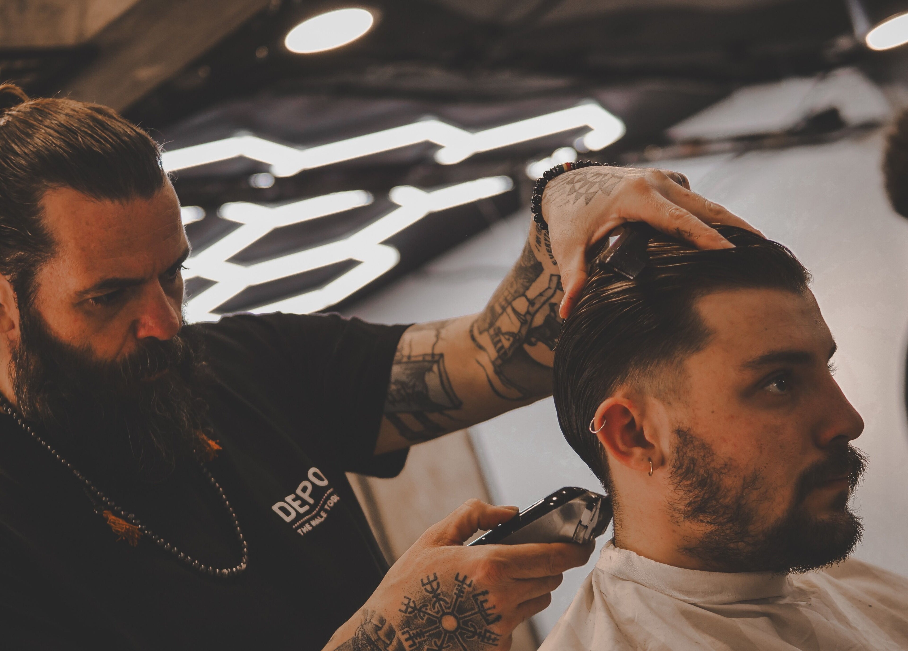 Barber styling a client's hair at Yuva by Clinton, Ħaż-Żebbuġ, MT in a modern setting.