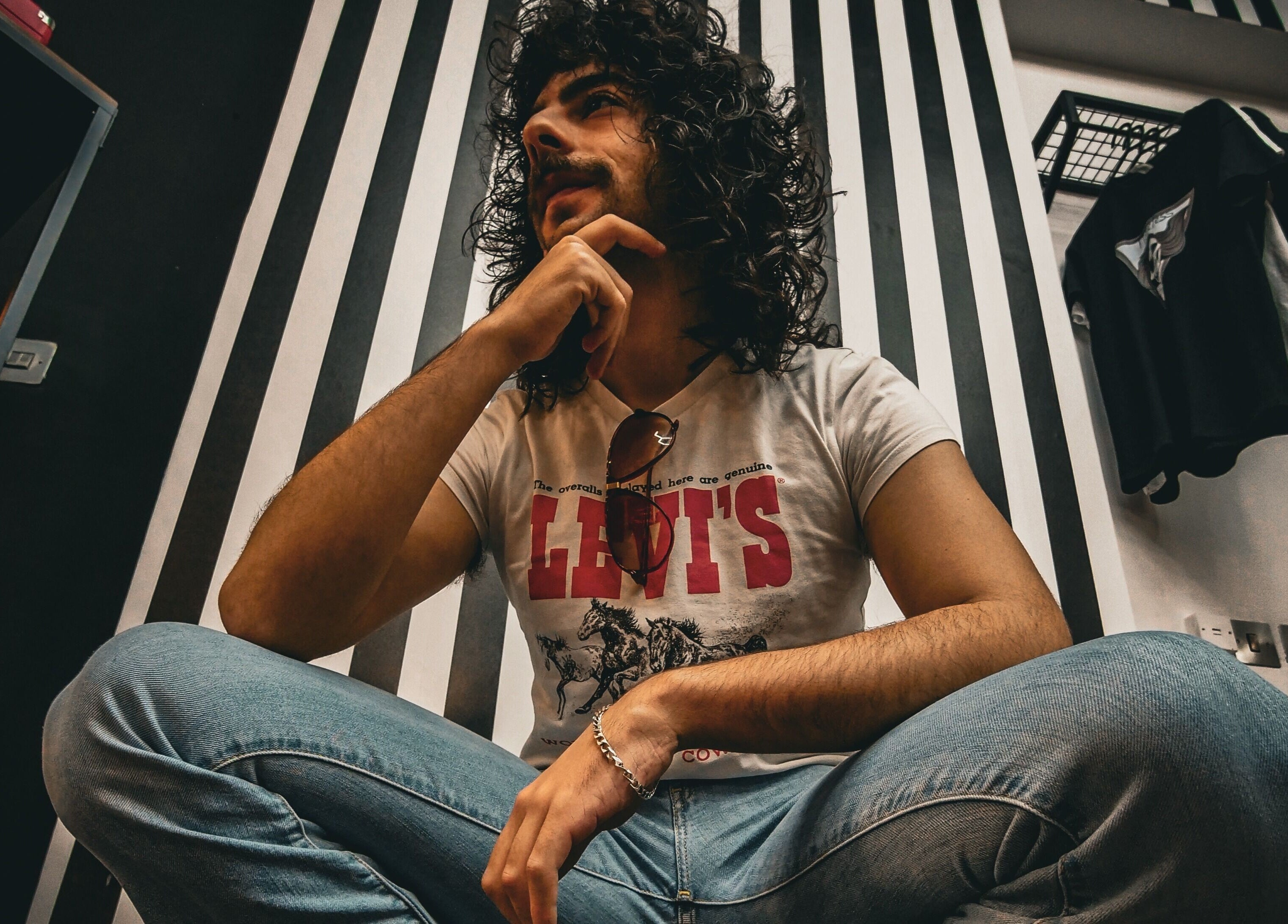 Stylish person at Yuva by Clinton in Ħaż-Żebbuġ, MT, with a modern striped background.