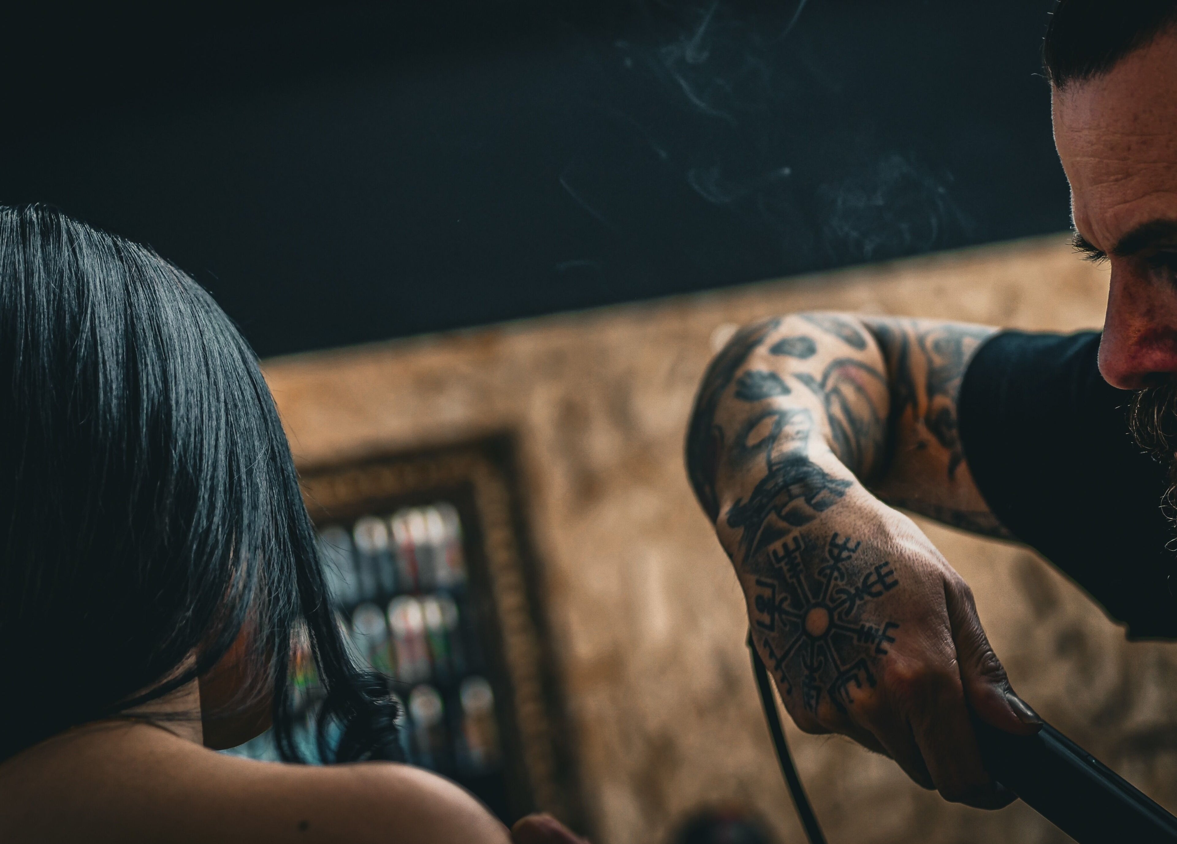 A stylist at Yuva by Clinton, Ħaż-Żebbuġ, MT, carefully straightens a client's hair.