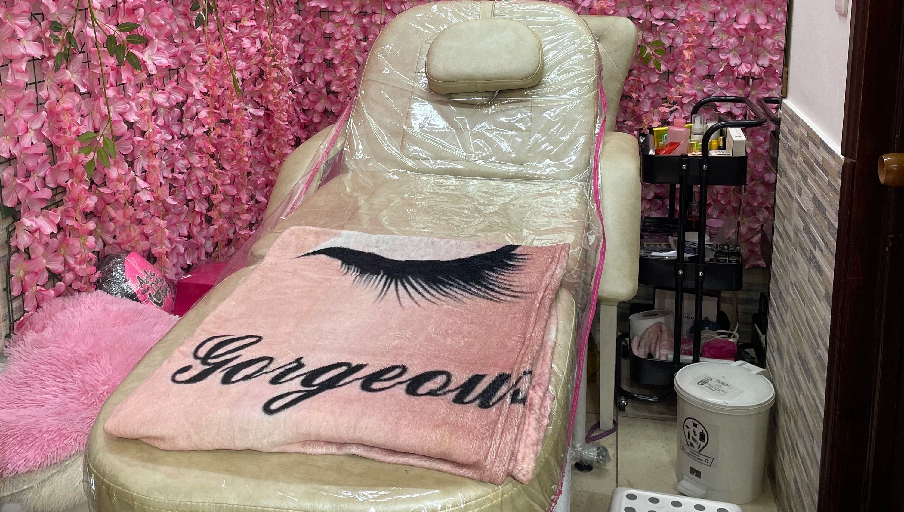 Cama de belleza en Andromeda Estudio De Belleza Y Moda, Bogotá, Cundinamarca, CO. Decoración de flores rosadas.