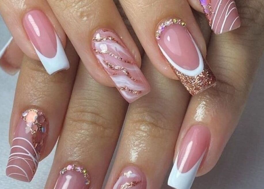 Uñas decoradas en Andromeda Estudio De Belleza Y Moda, Bogotá, Cundinamarca, CO, destacan por su diseño y brillo.