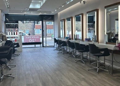 Interior of HAIR COLLECTIVE in London, England, GB featuring modern styling stations and sleek design.