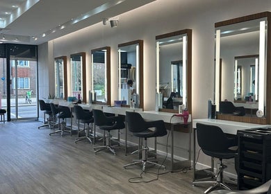 Modern styling area at HAIR COLLECTIVE, London, England, GB, featuring elegant salon stations and mirrors.