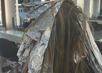 Hair coloring process using foil at HAIR COLLECTIVE, London, England, GB salon for vibrant, stylish look.
