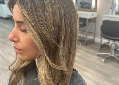 Woman with elegant blonde highlights at HAIR COLLECTIVE, London, England, GB, in a modern salon setting.