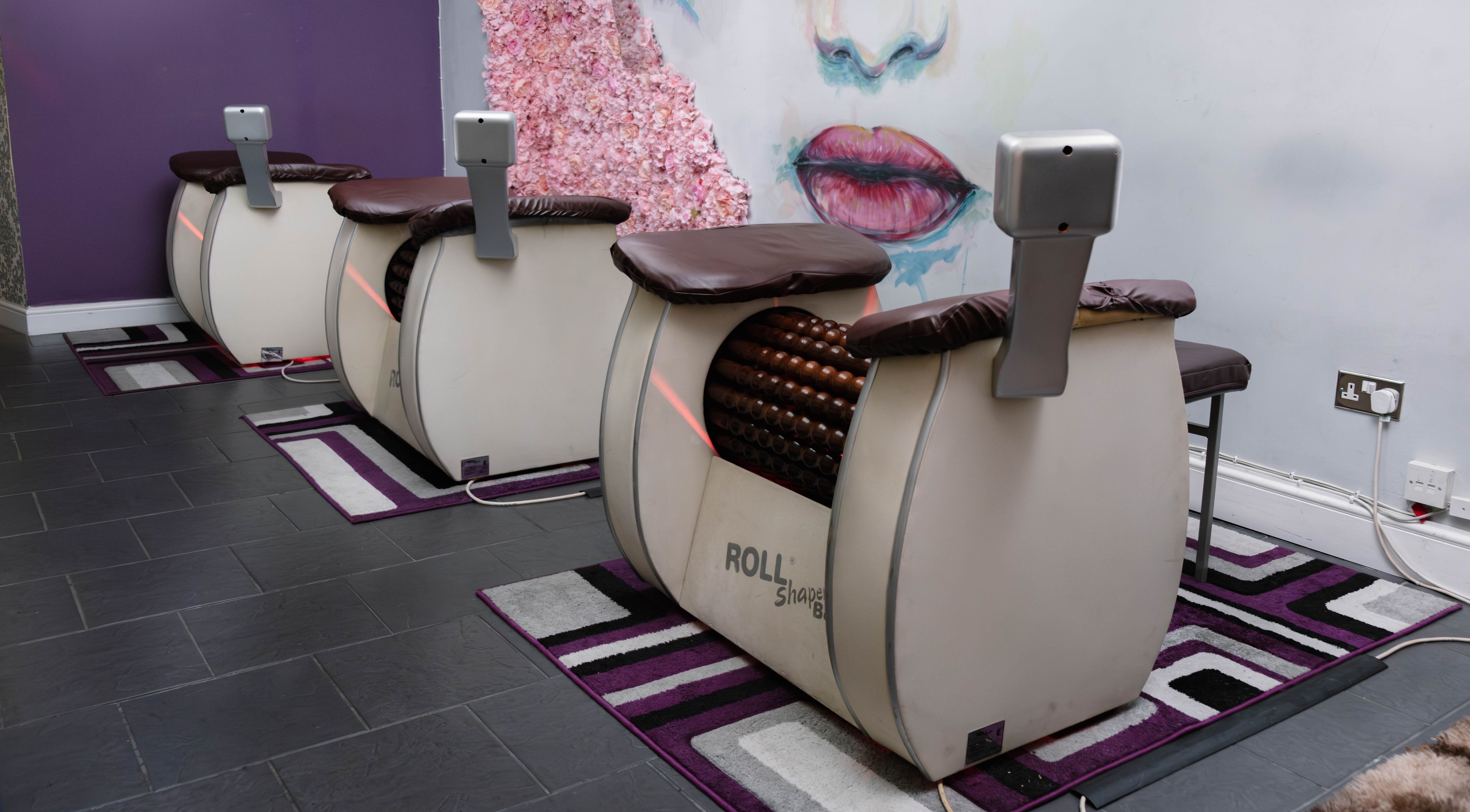 Modern massage machines at Studio Figura London City in London, England, GB, against a stylish mural wall.