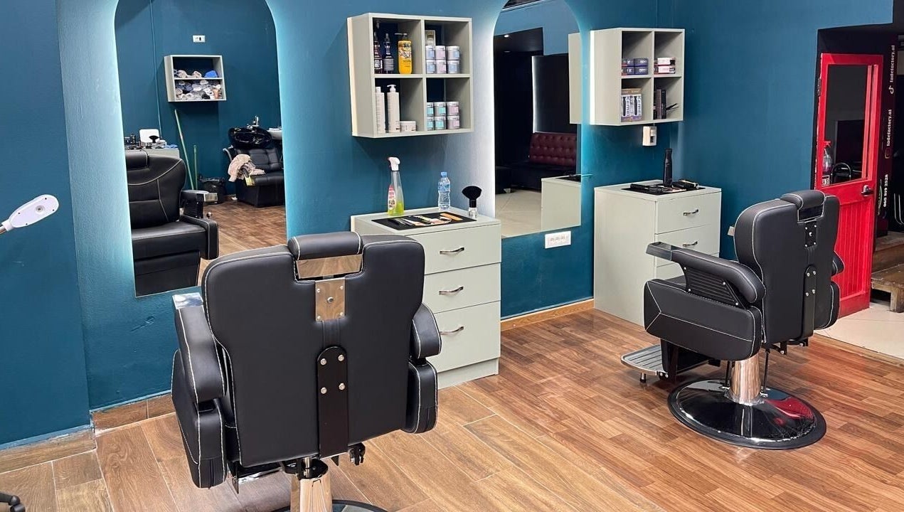 Modern salon interior at Fade Factory, Tiranë, Tirana County, AL, featuring sleek chairs and vibrant decor.