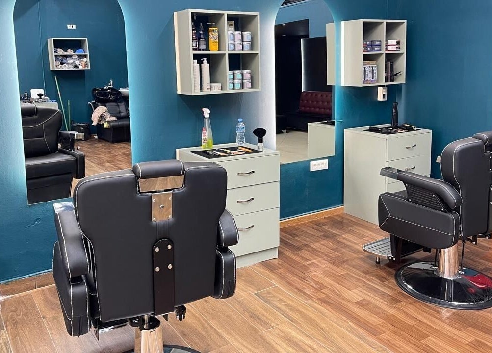 Modern salon interior at Fade Factory, Tiranë, Tirana County, AL, featuring sleek chairs and vibrant decor.