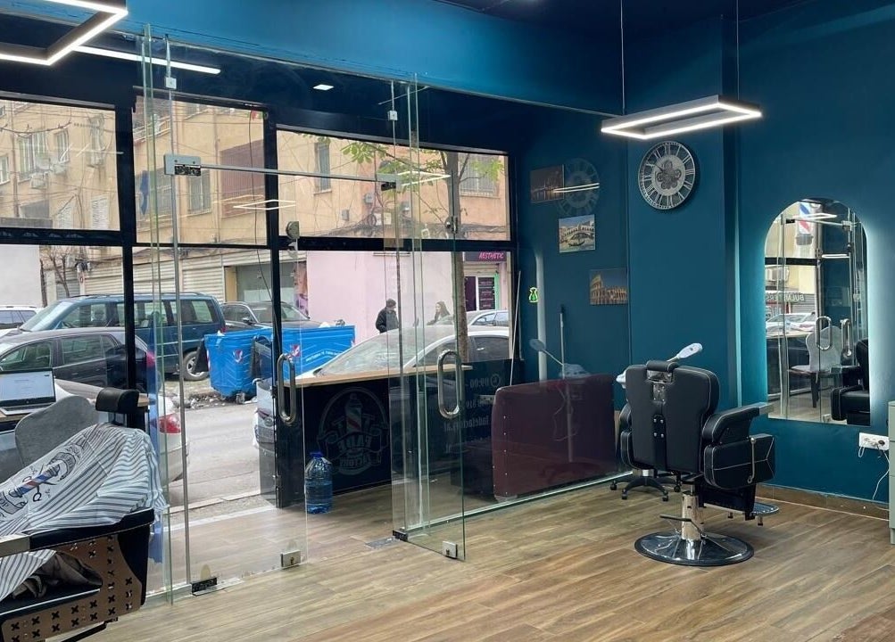 Fade Factory in Tiranë, Tirana County, AL showcases a stylish barber chair and modern interior decor.
