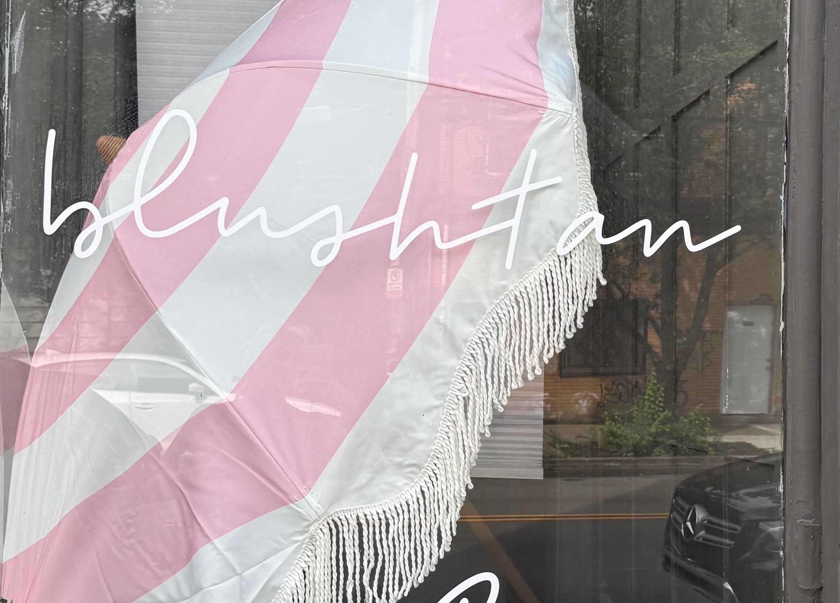 BlushTan Lawrenceville storefront with pink parasol, located in Pittsburgh, Pennsylvania, US.